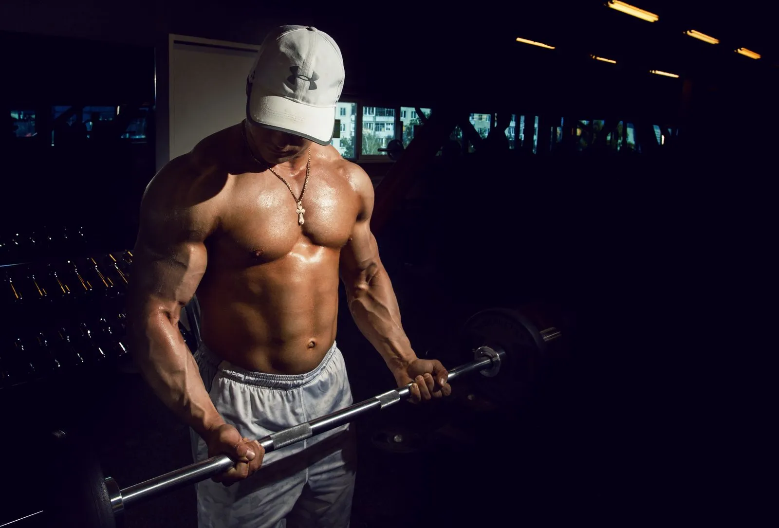 Athlete lifting a barbell in a dark training space; illustrative studio photography
