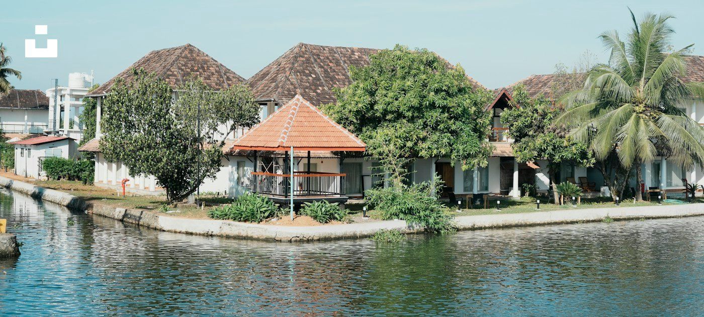 Palm-lined Kerala waterway beside waterside cottages